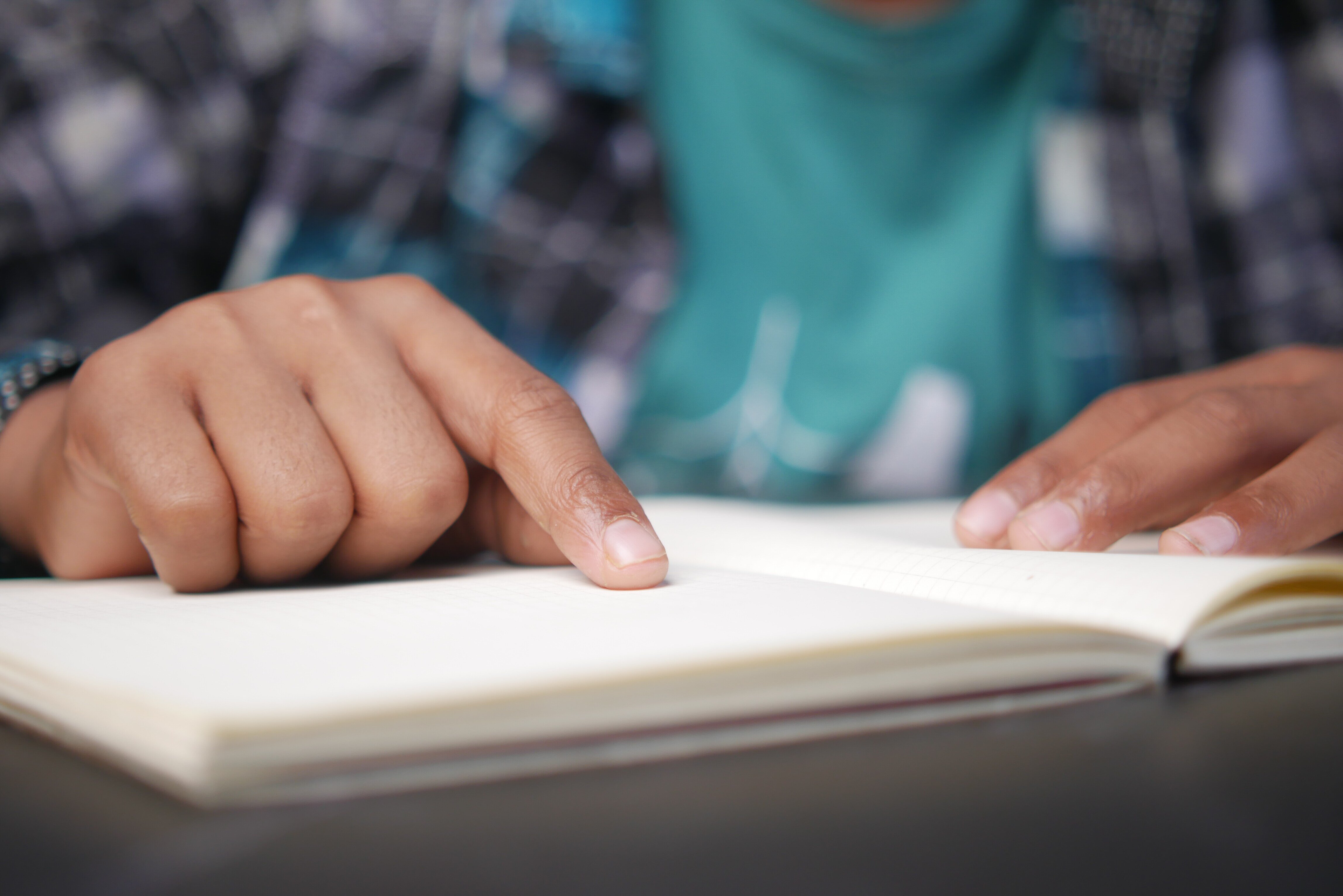 close-up-of-boy-hand-reading-a-book-2024-12-13-07-39-54-utc (1)